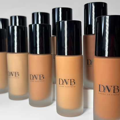 Row of DNB foundation bottles with black caps on a white background