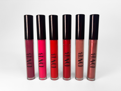 Set of six lip glosses with black caps on a white background