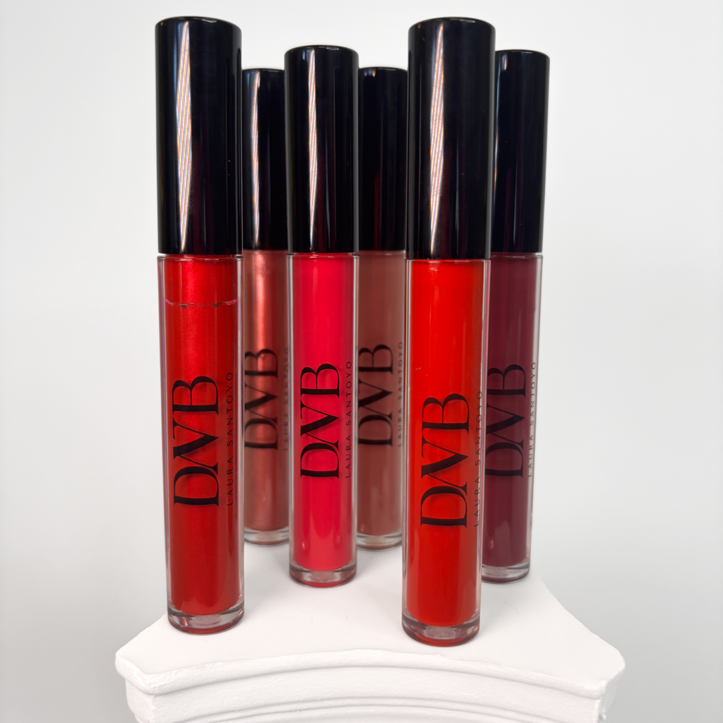 Set of red lip glosses with black caps on a white surface