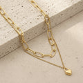 Gold chain double-layer mini heart necklace on a stone surface