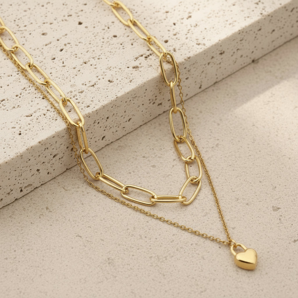 Gold chain double-layer mini heart necklace on a stone surface