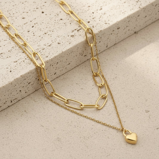 Gold chain double-layer mini heart necklace on a stone surface