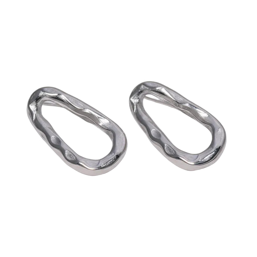 Two silver earrings on a textured white background
