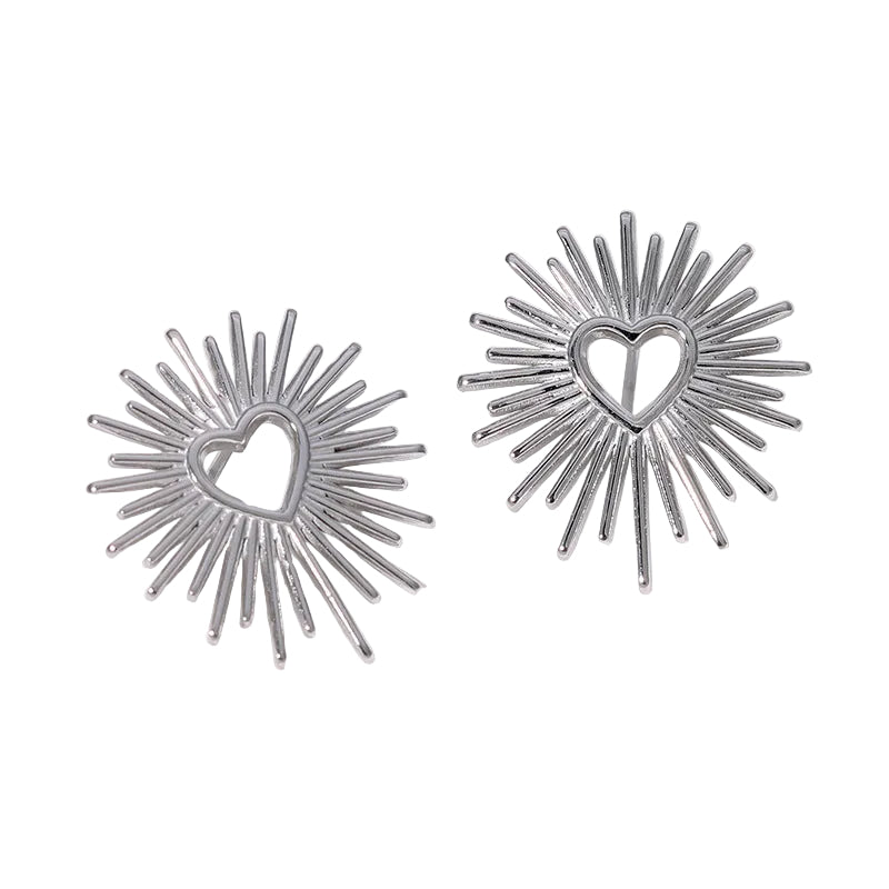 Silver sunburst earrings with heart centers on a white background